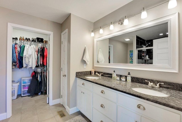 bathroom featuring walk in shower, vanity, and tile patterned flooring