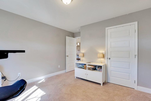 interior space featuring light carpet and baseboards
