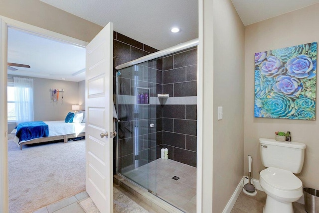 bathroom featuring toilet, ceiling fan, tile patterned floors, and a shower with door