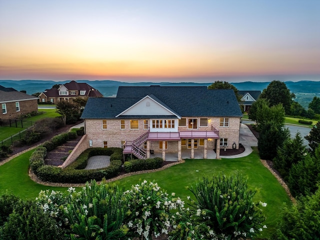 view of front of house with a wooden deck, a yard, and a patio