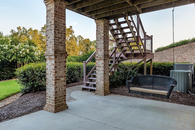 view of patio with central air condition unit and a deck