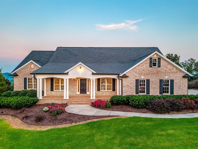 view of front of property with a porch and a yard