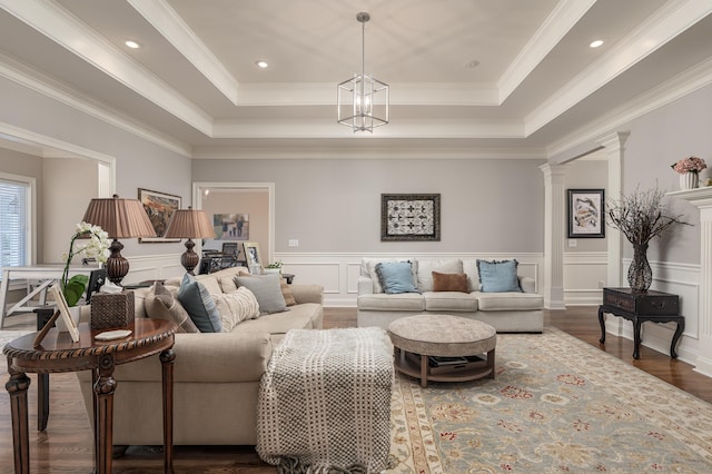 living room featuring dark hardwood / wood-style flooring, a raised ceiling, and ornamental molding