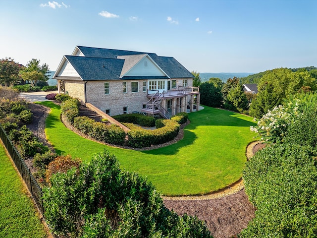 back of property featuring a wooden deck and a yard