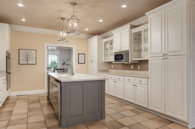 kitchen featuring an island with sink, white cabinetry, stainless steel appliances, and sink