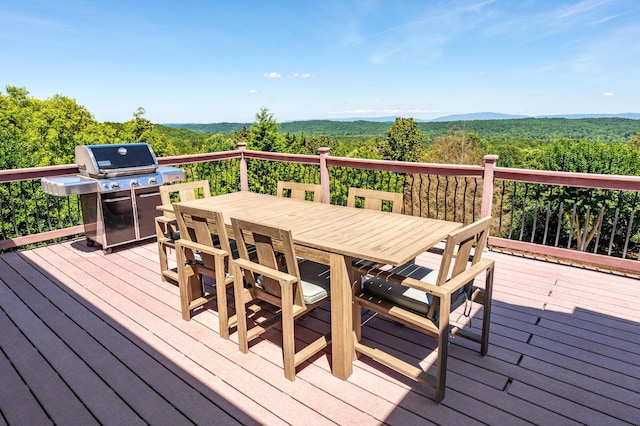 wooden deck featuring a mountain view and a grill