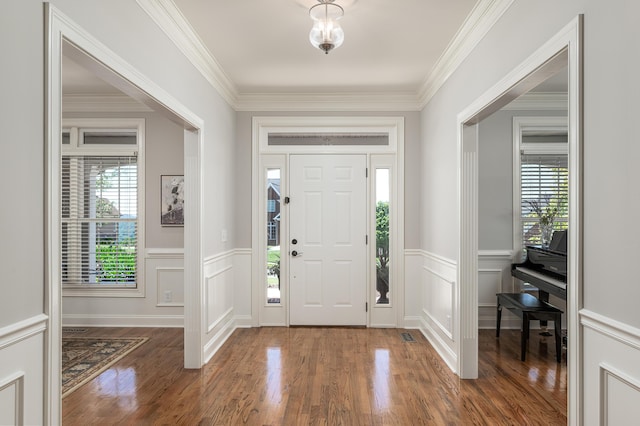 foyer featuring ornamental molding, dark wood-type flooring, and a wealth of natural light