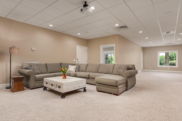 carpeted living room with a paneled ceiling