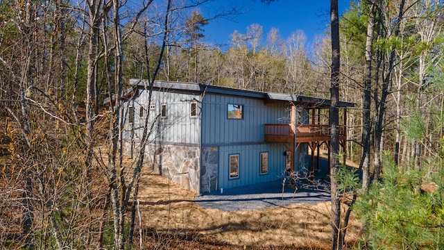 exterior space with driveway and a wooded view