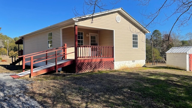 view of front of home with covered porch and a storage shed