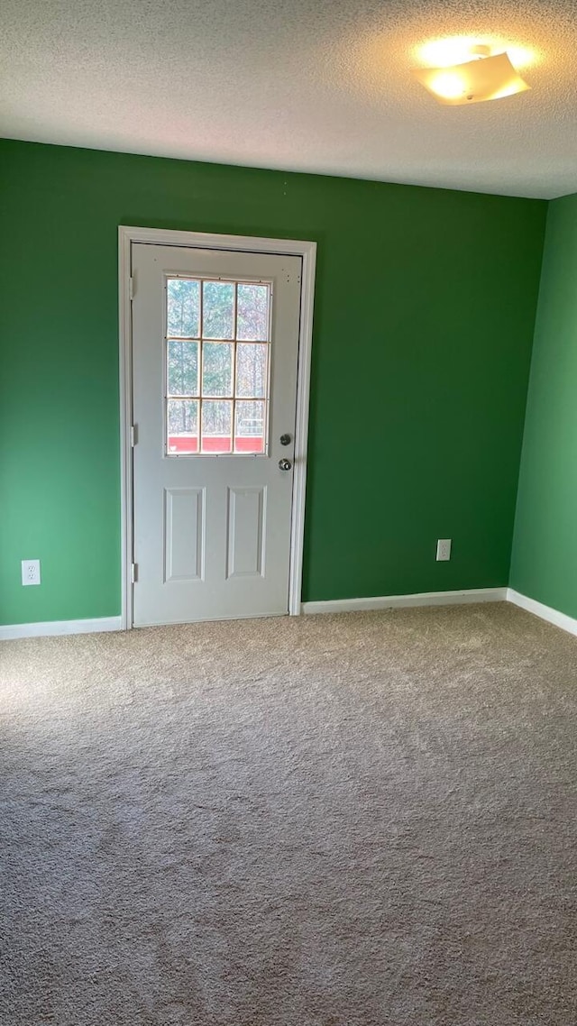 spare room with carpet floors and a textured ceiling