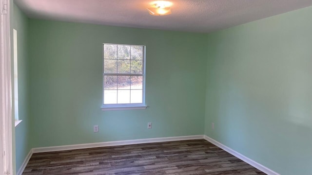 unfurnished room featuring a textured ceiling and dark wood-type flooring