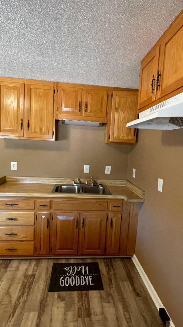 kitchen featuring a textured ceiling, dark hardwood / wood-style floors, and sink