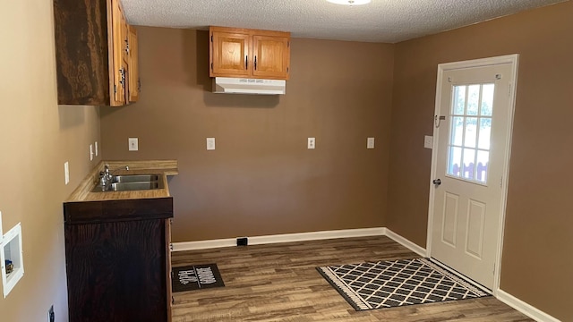 laundry area with sink, a textured ceiling, and hardwood / wood-style flooring