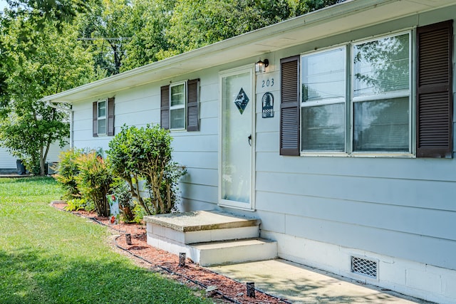 doorway to property featuring a yard