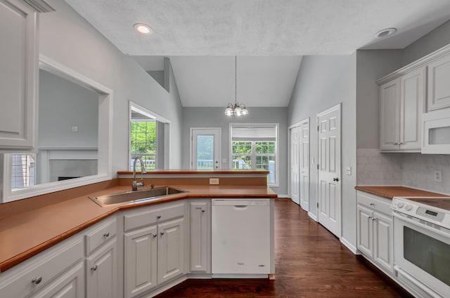 1031 Laurel Hill Dr, Dickson, TN 37055 - kitchen featuring white appliances, a sink, vaulted ceiling, dark wood finished floors, and a chandelier