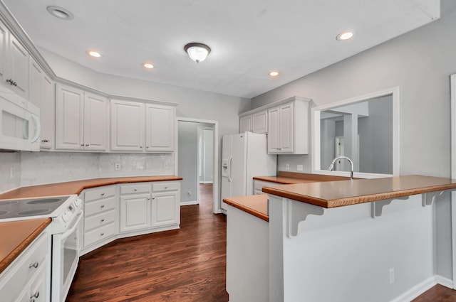 1031 Laurel Hill Dr, Dickson, TN 37055 - kitchen featuring white appliances, a kitchen bar, dark wood-style floors, white cabinetry, and a peninsula