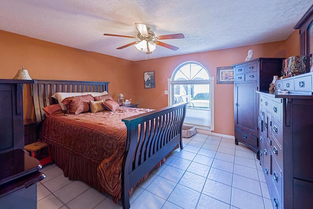 bedroom with light tile patterned floors, a ceiling fan, and a textured ceiling