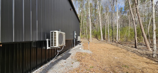 exterior space with ac unit and a wooded view