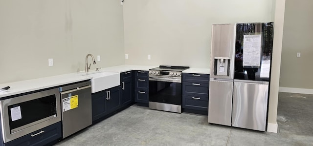 kitchen featuring concrete flooring, a sink, stainless steel appliances, and light countertops