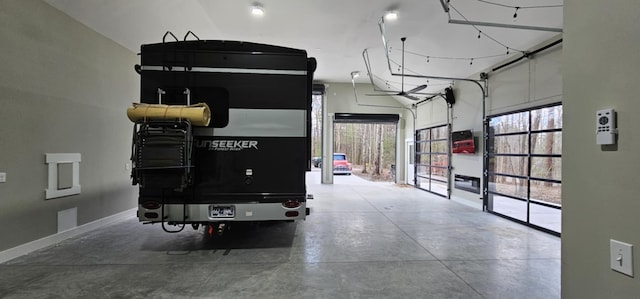 interior space with a wealth of natural light, baseboards, and concrete flooring