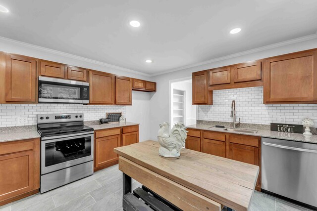 6833 Buck Trail Dr, Harrison, TN 37341 - kitchen with stainless steel appliances, ornamental molding, a sink, brown cabinetry, and backsplash