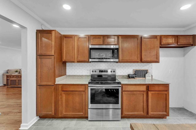 6833 Buck Trail Dr, Harrison, TN 37341 - kitchen with stainless steel appliances, ornamental molding, tasteful backsplash, brown cabinets, and recessed lighting