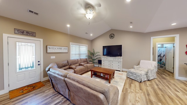 living room featuring light wood-type flooring and vaulted ceiling