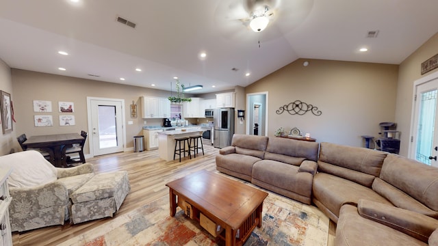 living room featuring light hardwood / wood-style flooring and lofted ceiling