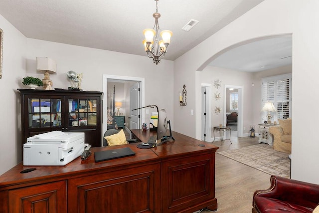 office space featuring light hardwood / wood-style flooring and a notable chandelier