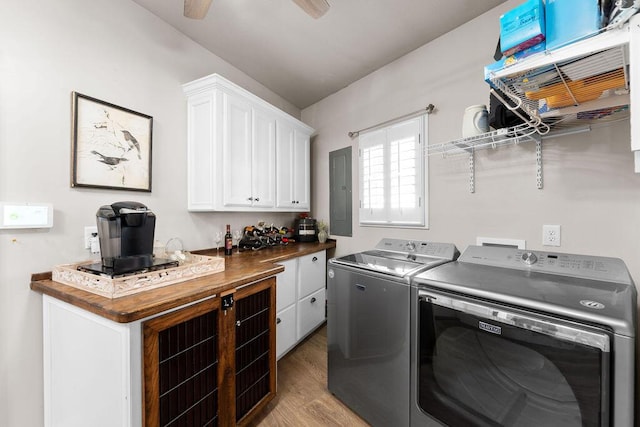 washroom featuring ceiling fan, electric panel, cabinets, light hardwood / wood-style floors, and washer and dryer