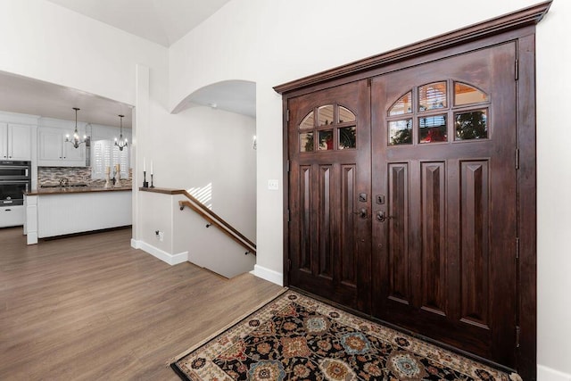 foyer with hardwood / wood-style flooring and a chandelier