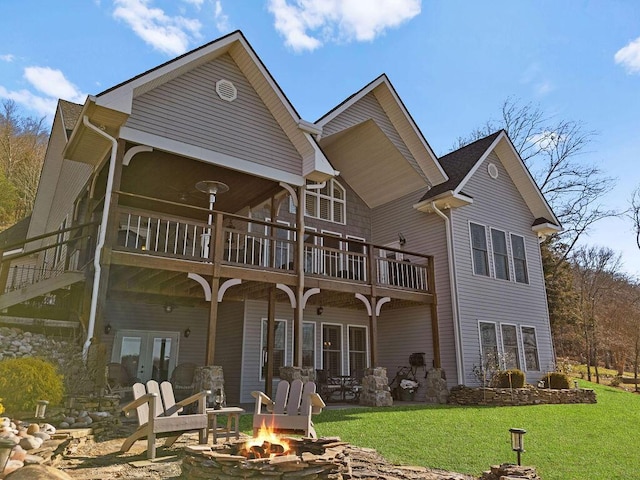 rear view of property featuring a patio, a yard, french doors, and an outdoor fire pit