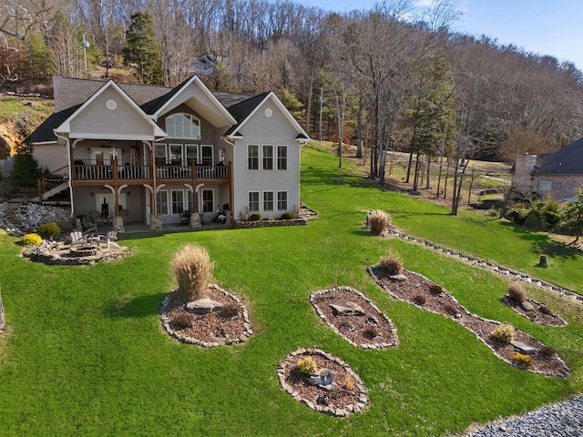 rear view of house with a deck, a patio, and a lawn