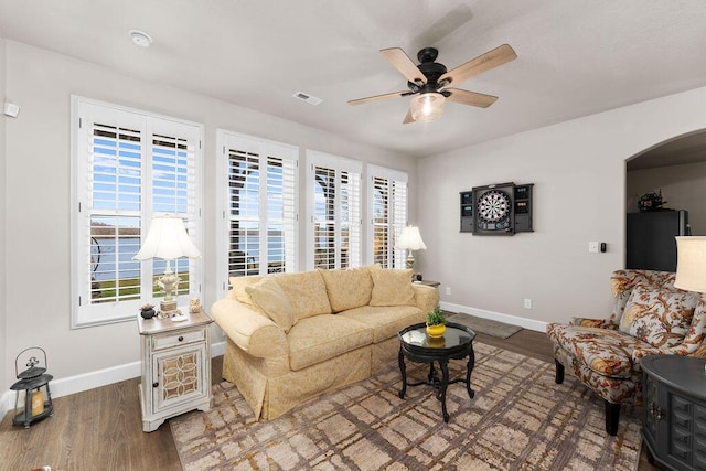 living room featuring ceiling fan, plenty of natural light, and wood-type flooring