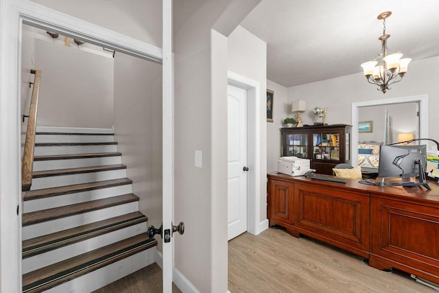 stairway with an inviting chandelier and hardwood / wood-style floors