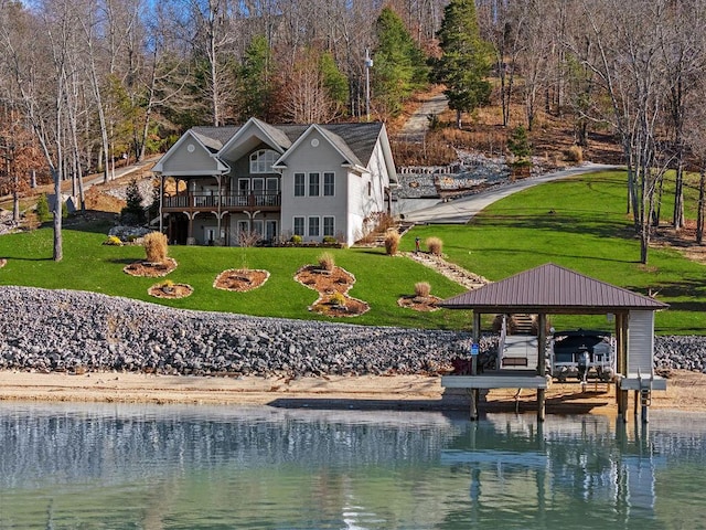 back of house with a water view, a yard, and a gazebo