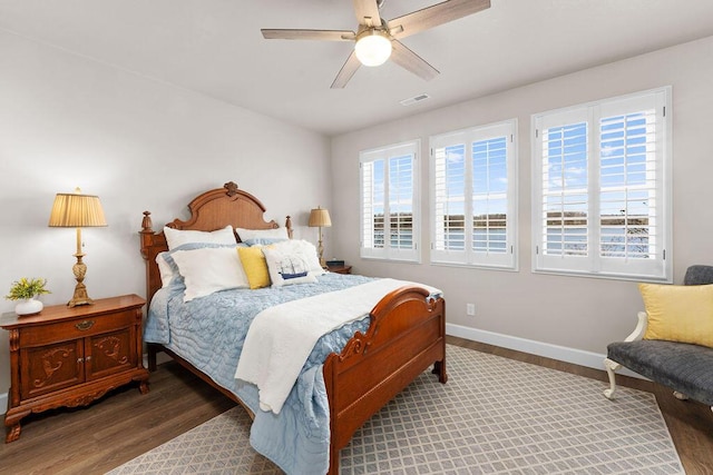 bedroom with multiple windows, dark hardwood / wood-style floors, and ceiling fan