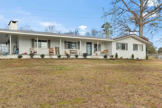 single story home featuring covered porch and a front yard