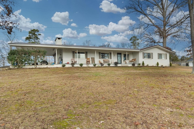 single story home with a front yard, a carport, and covered porch