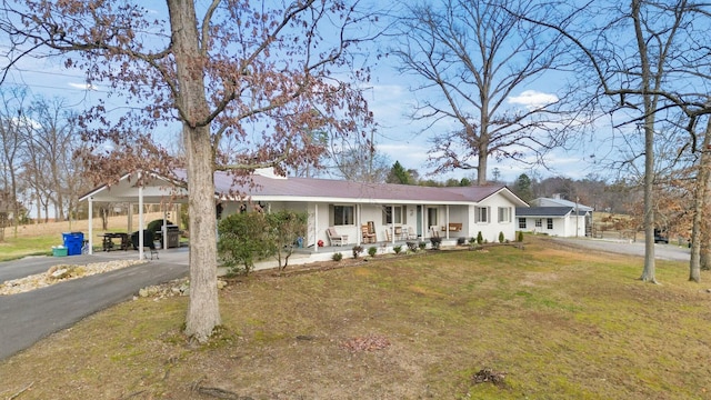 ranch-style house with a carport, a porch, and a front yard