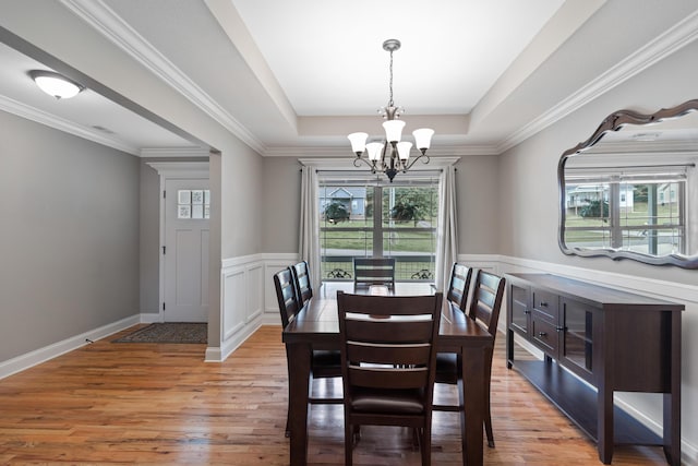 7083 Blue Springs Rd SE, Cleveland, TN 37311 - dining space with a chandelier, a raised ceiling, light wood finished floors, a wainscoted wall, and crown molding