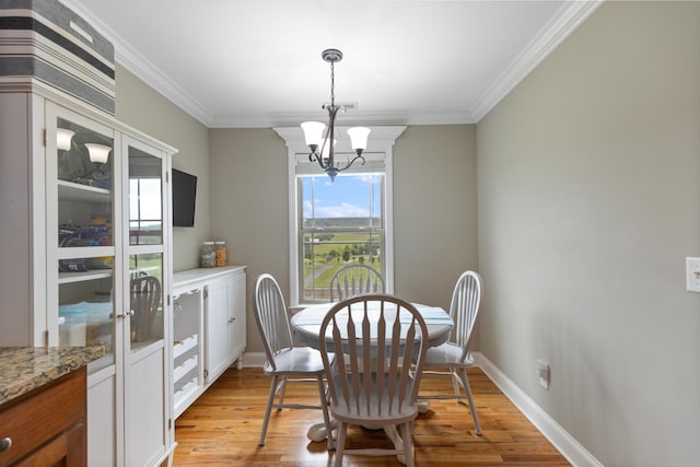 7083 Blue Springs Rd SE, Cleveland, TN 37311 - dining area with light wood-style flooring, a chandelier, and crown molding