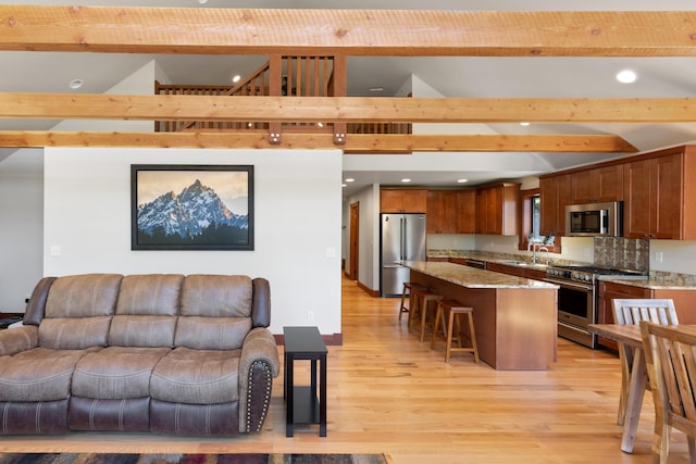 living room with lofted ceiling with beams, sink, and light wood-type flooring