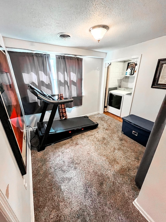 exercise room with a textured ceiling, carpet floors, separate washer and dryer, and visible vents