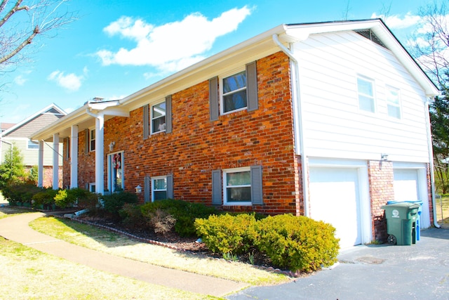 view of home's exterior with driveway, an attached garage, and brick siding