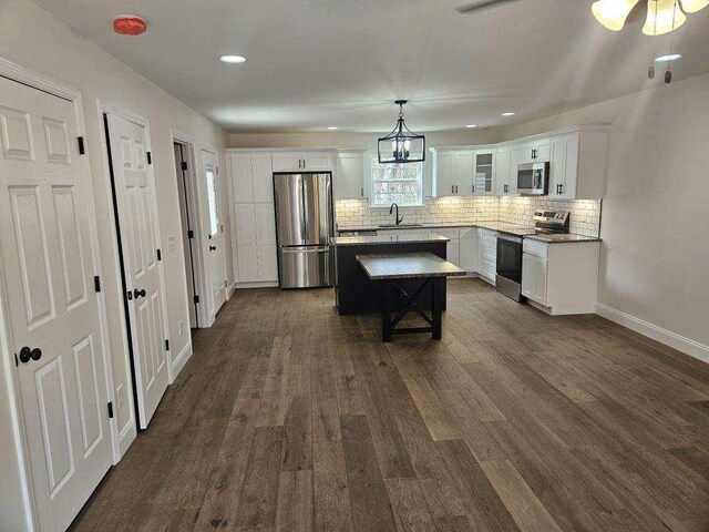 kitchen featuring white cabinets, sink, tasteful backsplash, light stone counters, and stainless steel appliances