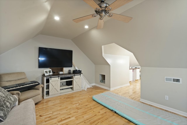 living room with visible vents, baseboards, light wood-type flooring, a ceiling fan, and vaulted ceiling