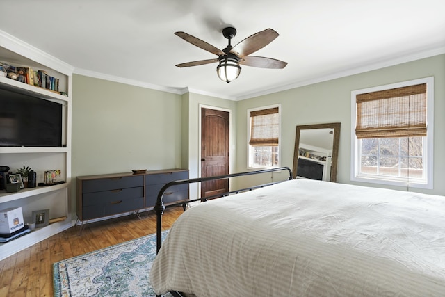 bedroom featuring crown molding, ceiling fan, and wood finished floors