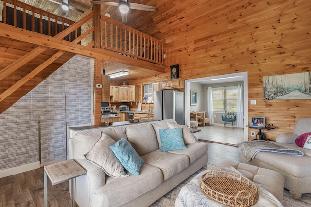 living room with wood walls, wooden ceiling, high vaulted ceiling, beamed ceiling, and light hardwood / wood-style floors